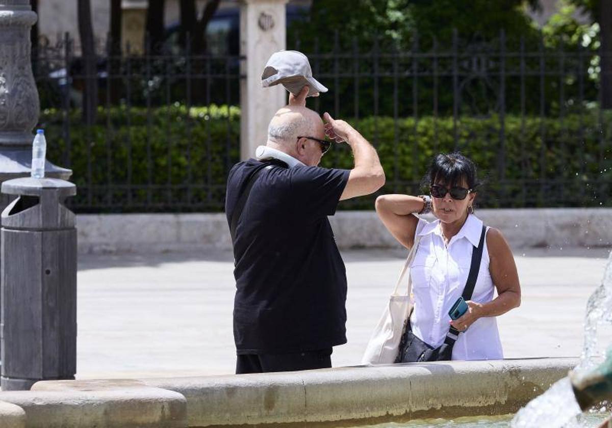 Dos personas se refrescan en Valencia ante las altas temperaturas.