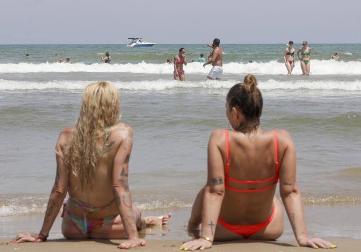 Dos mujeres combaten al calor en la playa en Valencia.