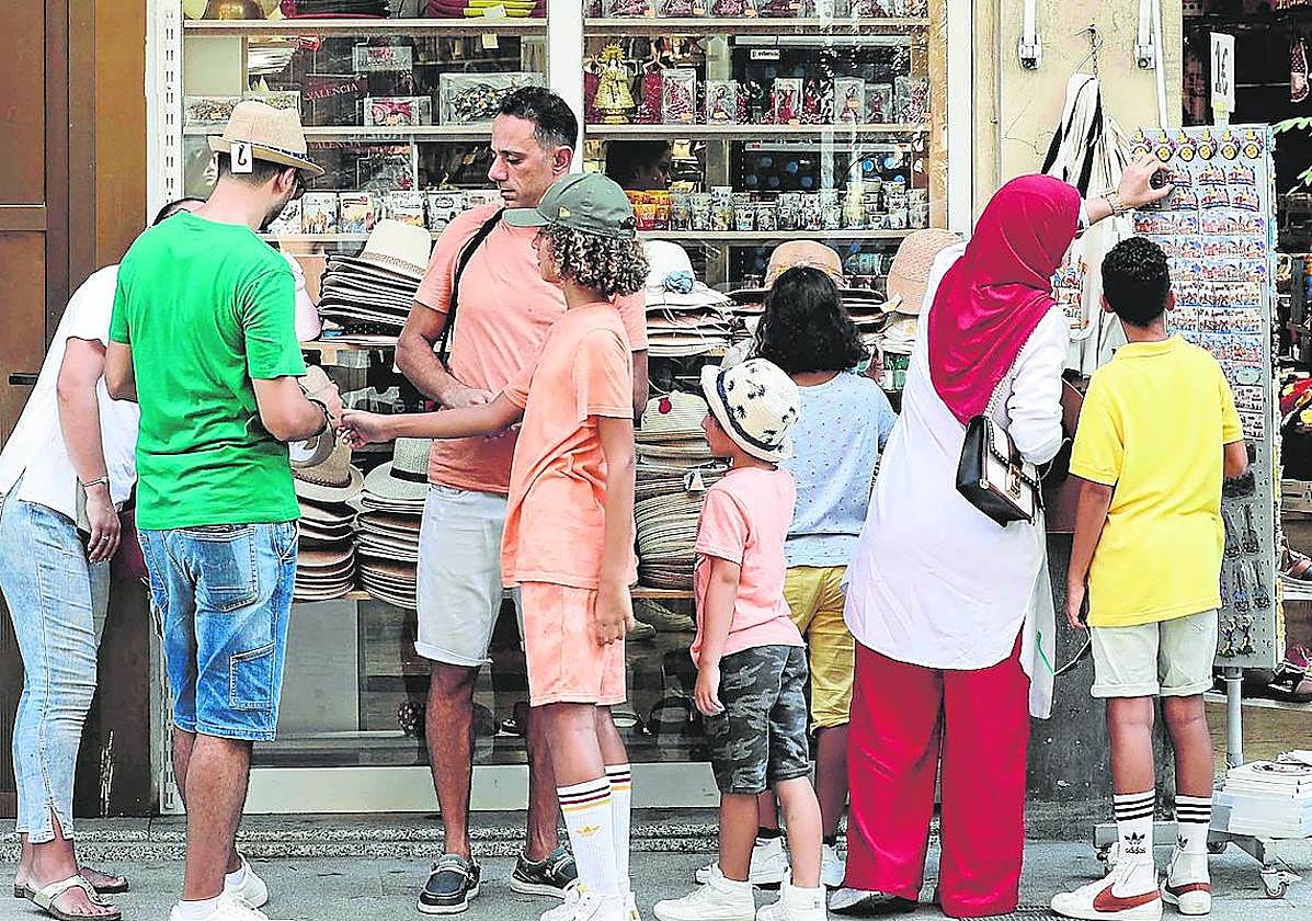 Compra. Familia de turistas buscando souvenirs en una tienda de la ciudad.