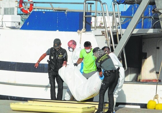 Los operarios de la Guardia Civil sacan el cuerpo sin vida de un inmigrante de la costa de Denia.