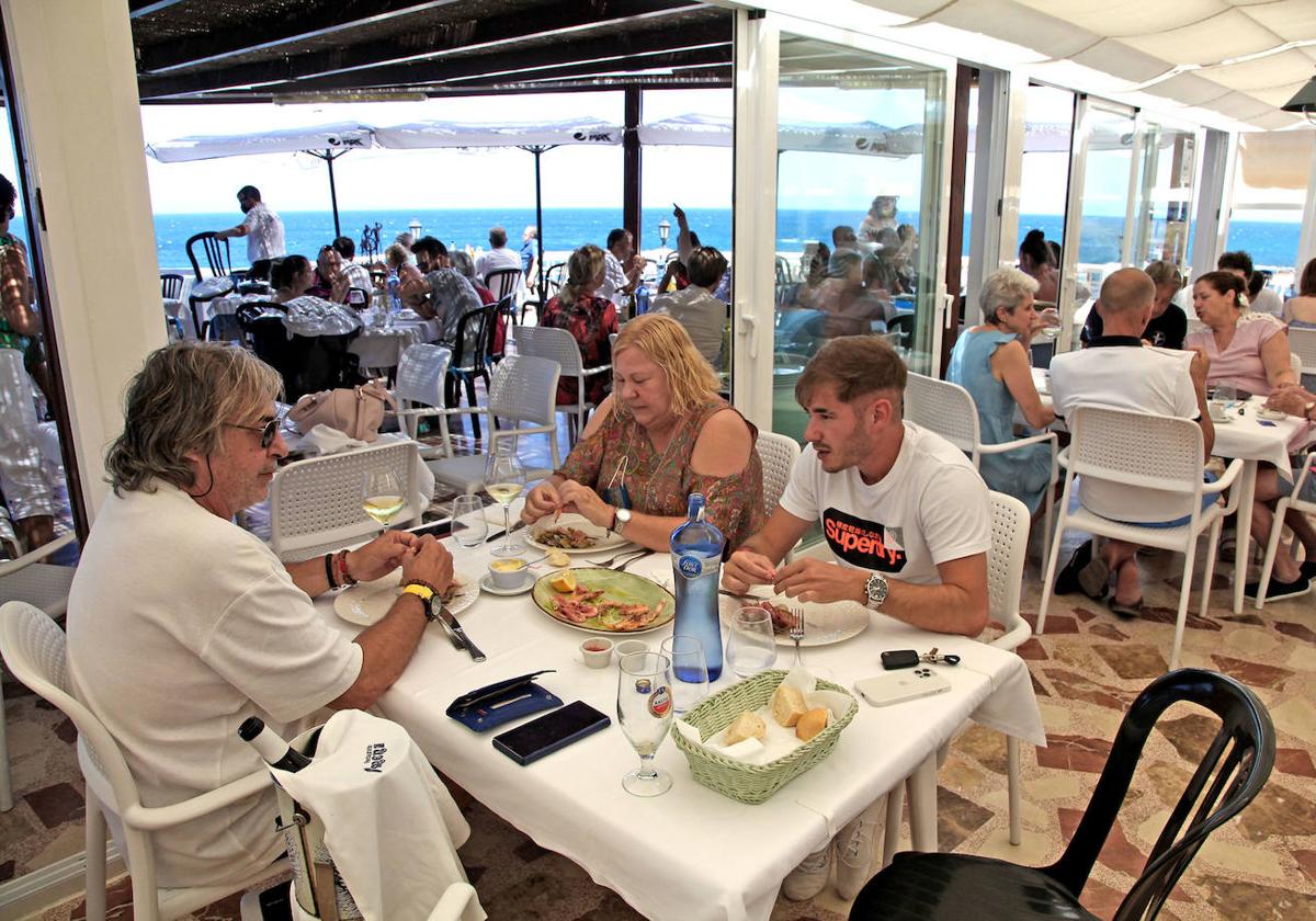 Comensales comen gambas en el restaurante Mena de Dénia.