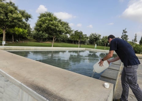 Imagen secundaria 1 - Los concejales Carlos Mundina y Juan Carlos Caballero, durante la toma de muestras; un operario reponiendo agua en una balsa y cierre del Parque Central.