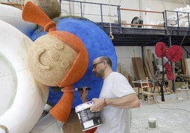 Vicente Julián García pintando una parte de la carroza.