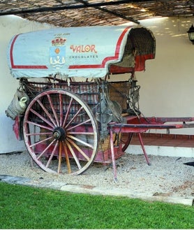 Imagen secundaria 2 - Instalaciones antiguas y actuales de la fábrica en la Vila Joiosa y el carro que se puede ver en el museo.