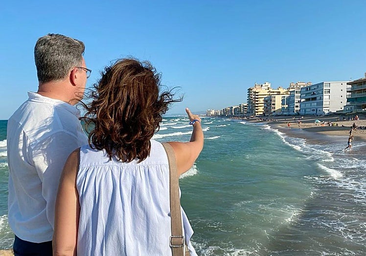 Imagen principal - El senador Vicente Martínez y la líder del PP de Tavernes, Eva Palomares, de espaldas, observando el estado de la playa; otros edificios dañados y donde los propietarios han tenido que colocar materiales provisionales para acceder a la arena. 