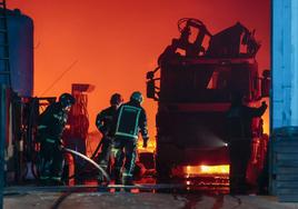 Varios bomberos intentan controlar las llamas del incendio de Castellón.