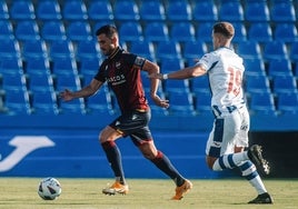 Postigo conduciendo el balón ante la presión de un rival.