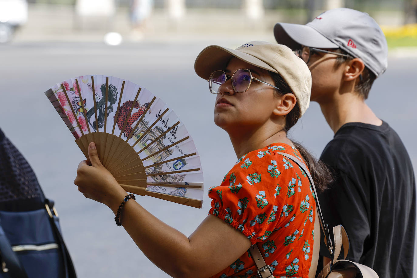 Una mujer se abanica en la calle durante la ola de calor.