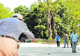 Jubilados juegan a la petanca en un parque.