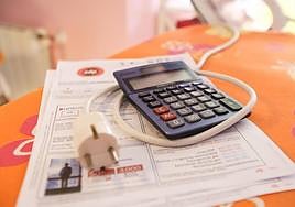 Una calculadora junto a una factura de la luz.