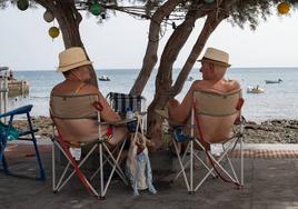 Dos personas se refugian a la sombra de la ola de calor.