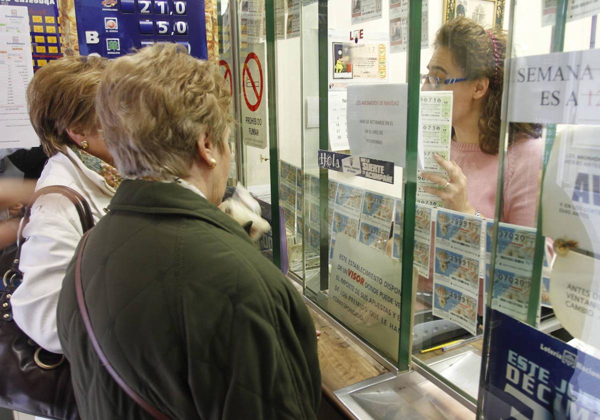 Una pareja de jugadoras frente a la ventanilla de una administración de Loterías y Apuestas del Estado