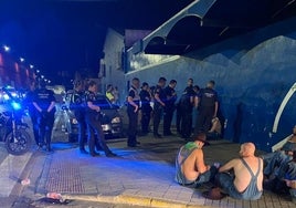 Un grupo de policías identifica a los sospechosos, algunos de ellos sentados en el suelo.