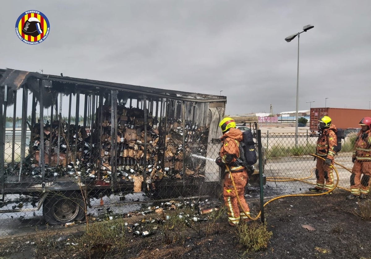 Un equipo de bomberos termina de sofocar el incendio del camión.