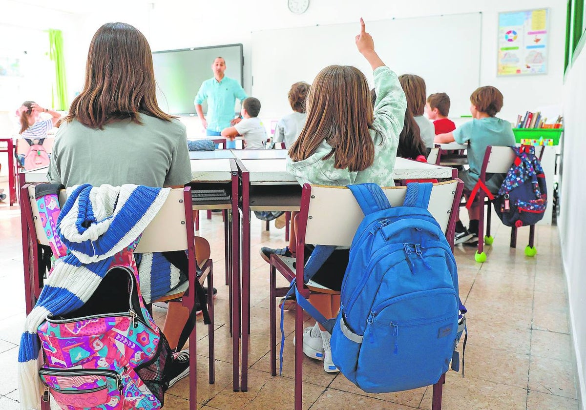 Una alumna levanta la mano para intervenir en clase.