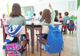 Una alumna levanta la mano para intervenir en clase.