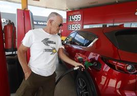 Un conductor pone gasolina en una estación de servicio low-cost.