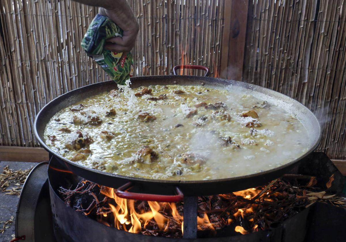 Un participante cocinando una paella en el concurso de Sueca.