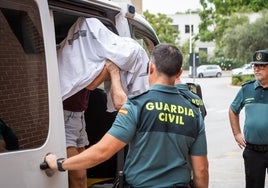 La homicida se tapa la cara con una sábana antes de bajar del furgón.