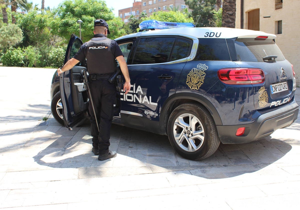 Agente de la Policía Nacional junto al coche en una imagen de archivo.