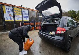 Un hombre carga una botella de butano en el coche