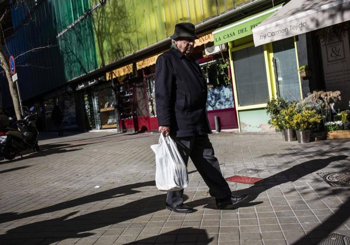 Un pensionista camina por la calle.