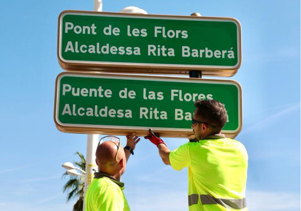 Operarios cambian el nombre del puente este jueves por la mañana.