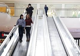 Varias personas en unas escaleras mecánicas de un centro comercial