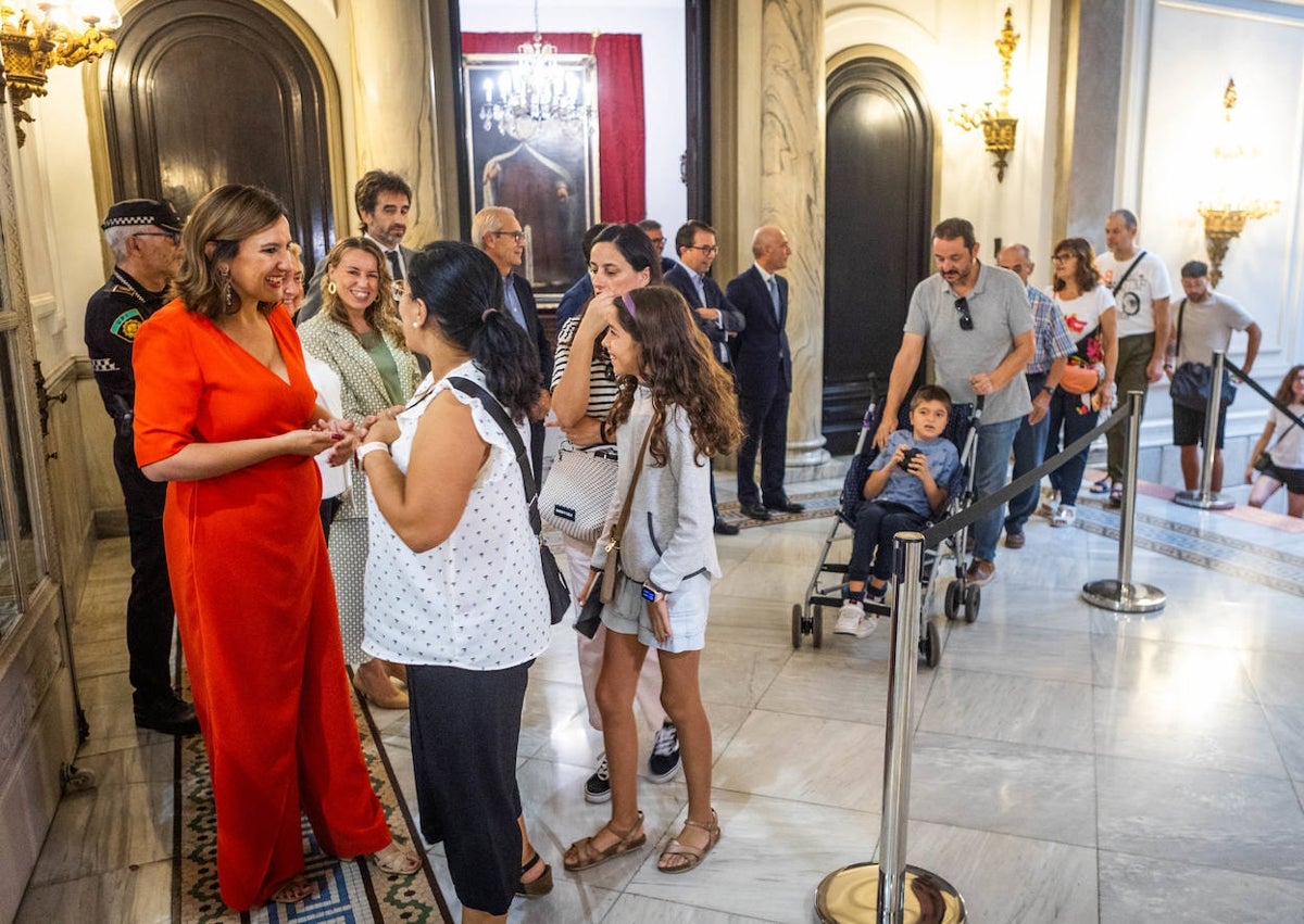 Imagen secundaria 1 - Grupos políticos junto a la Senyera, con la ausencia de Vox, María José Catalá dando la bienvenida a los visitantes y colas de acceso.