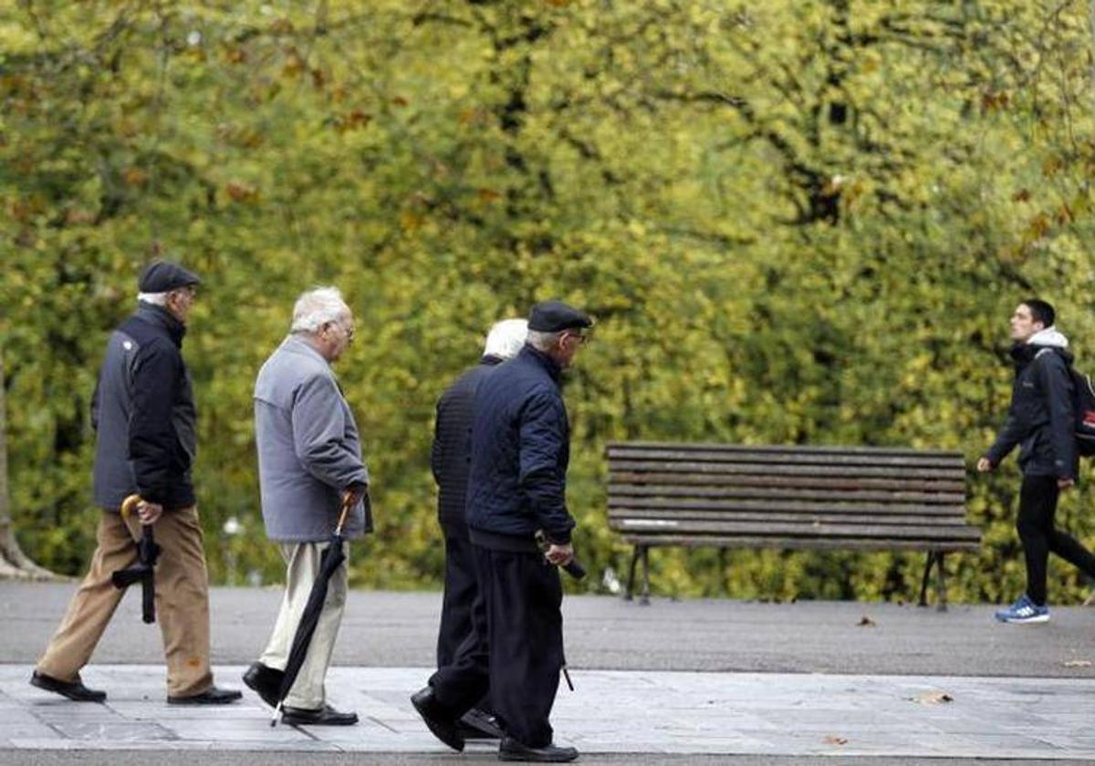 Varios pensionistas paseando por un parque en una imagen de archivo.