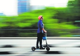 Una persona recorre Barcelona en patinete eléctrico.