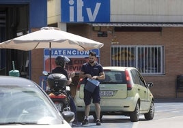 Un trabajador atiende a un conductor la estación de ITV de Vara de Quart de Valencia.