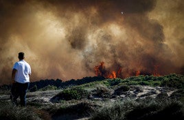 Un vecino observa las llamas del incendio declarado este sábado en El Saler.