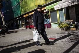 Un pensionista camina por la calle.