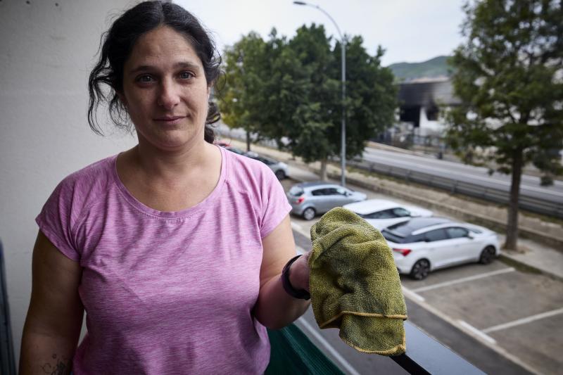 Trini García recoge el polvo negro que ha llegado a su casa procedente del incendio.