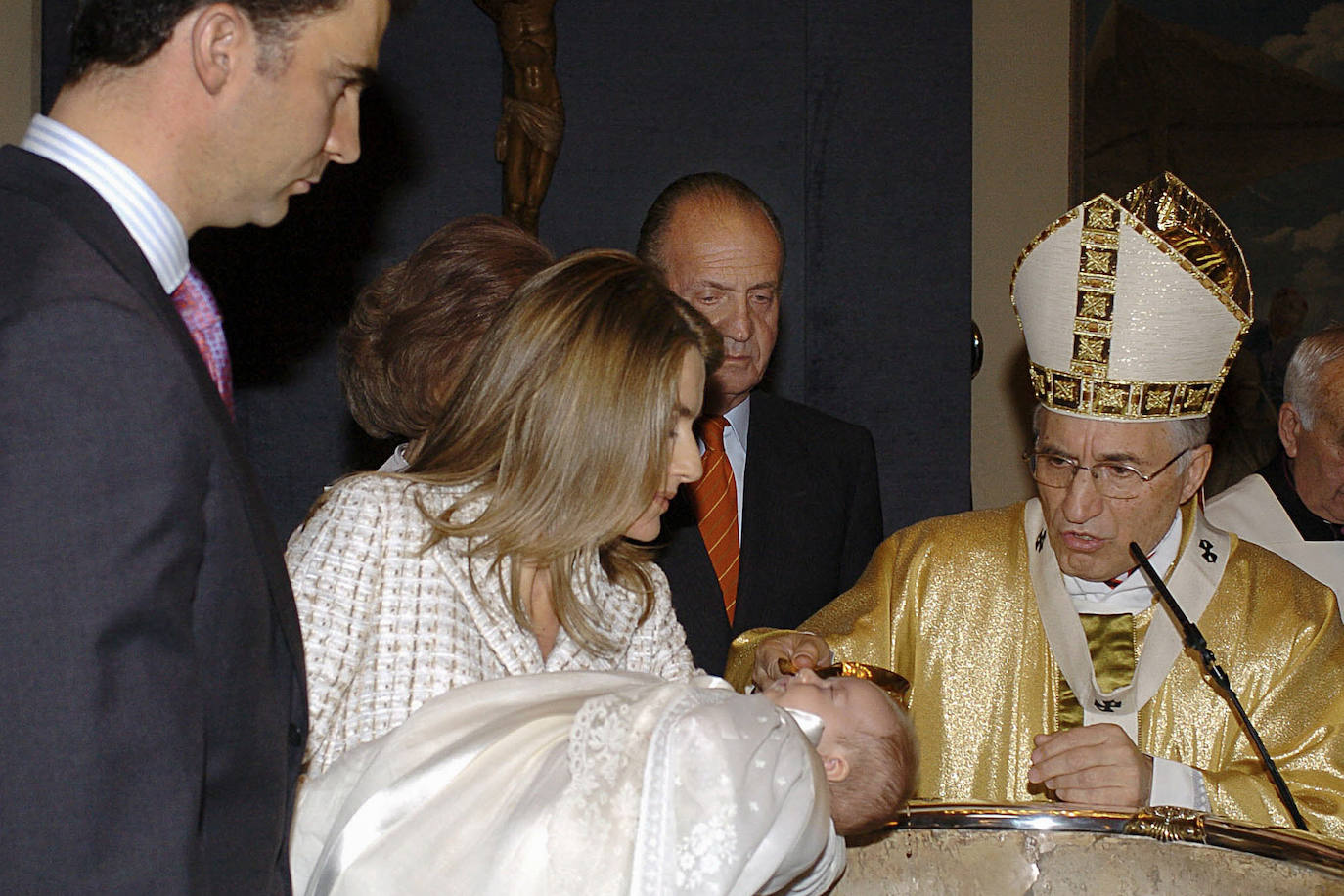 La princesa Leonor, en brazos de su madre, la reina Letizia, junto al rey Felipe y los reyes eméritos Juan Carlos y Sofía, el 14 de enero de 2006, durante su bautizo oficiado por el arzobispo de Madrid, el cardenal Antonio María Rouco Varela (d), en el vestíbulo del Palacio de la Zarzuela. 