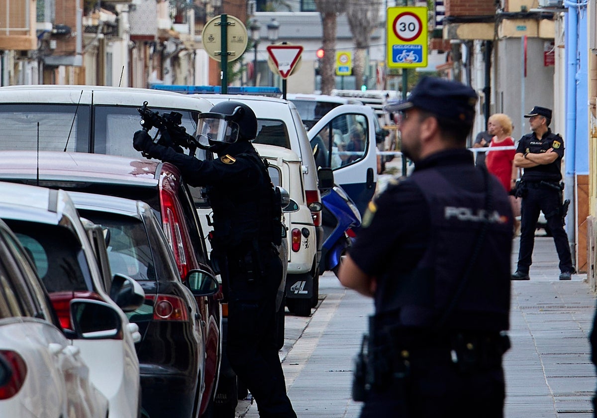 Varios policías vigilan la casa donde creían que se había atrincherado el autor del tiroteo.