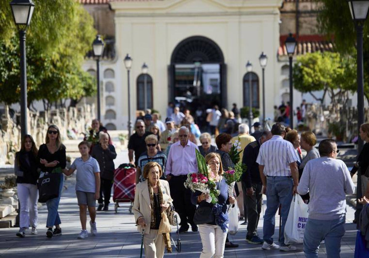 Familiares acuden al cementerio municipal de Valencia a dejar flores.