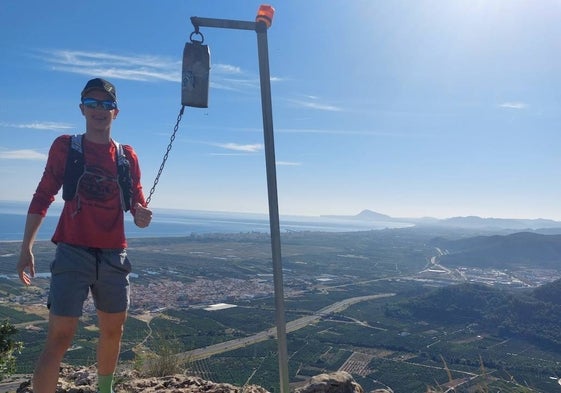 Un corredor cumple con la tradición de hacer sonar el cencerro de l'Esquellot de Xeraco.