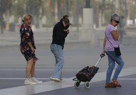 Viandantes pasean por Valencia durante las peores rachas de viento,