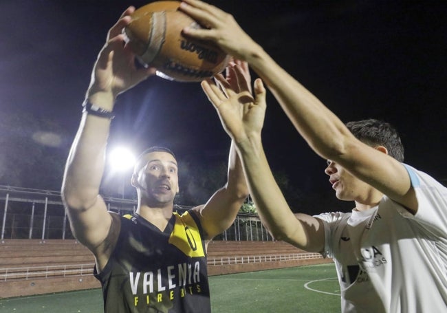 El jugador de los Valencia Firebats enseña al joven de Algemesí a lanzar el balón de fútbol americano.