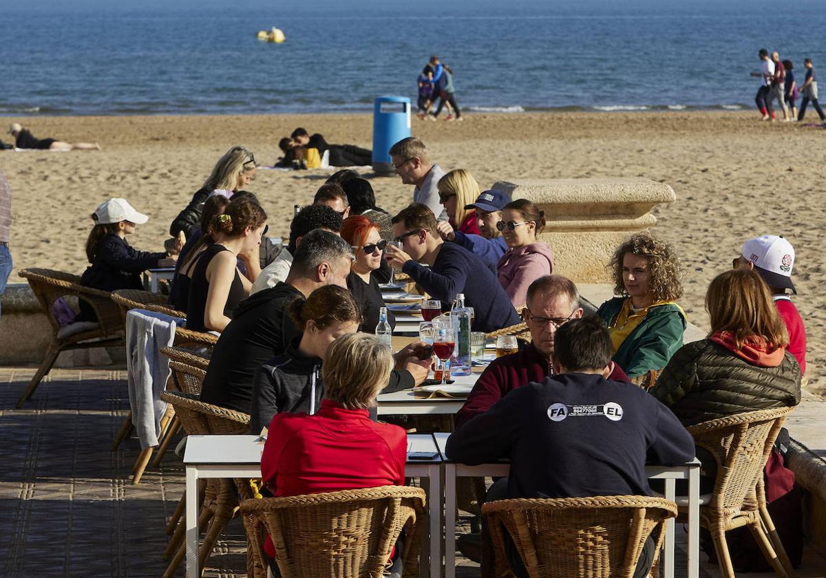 Varias personas disfrutando del sol y el buen tiempo en la playa de la Malvarrosa, imagen de archivo.