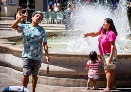 Una pareja se refresca en la plaza de la Virgen.