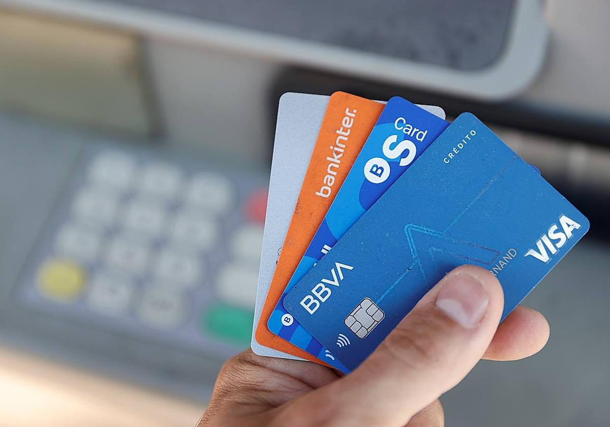 Una persona muestra las diferentes tarjetas que le permiten sacar dinro de un cajero, en una imagen de archivo