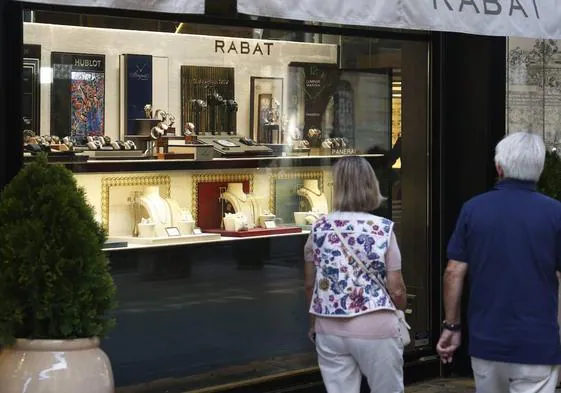 Una pareja mira el escaparate de una joyería de la calle Colón de Valencia.
