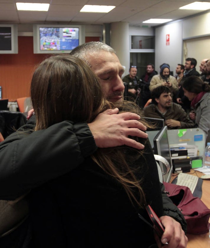 Imagen secundaria 2 - Trabajadores muestran su acreditación para entrar. El momento de apertura de la verja y el reencuentro con los compañeros de turno en el interior de la sede