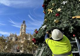 Un operario colocando el tapiz en la plaza del Ayuntamiento.