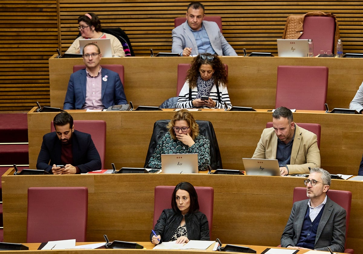 Rebeca Torró, junto al escaño vació de Ximo Puig, y Arcadi España, en un pleno de Les Corts.