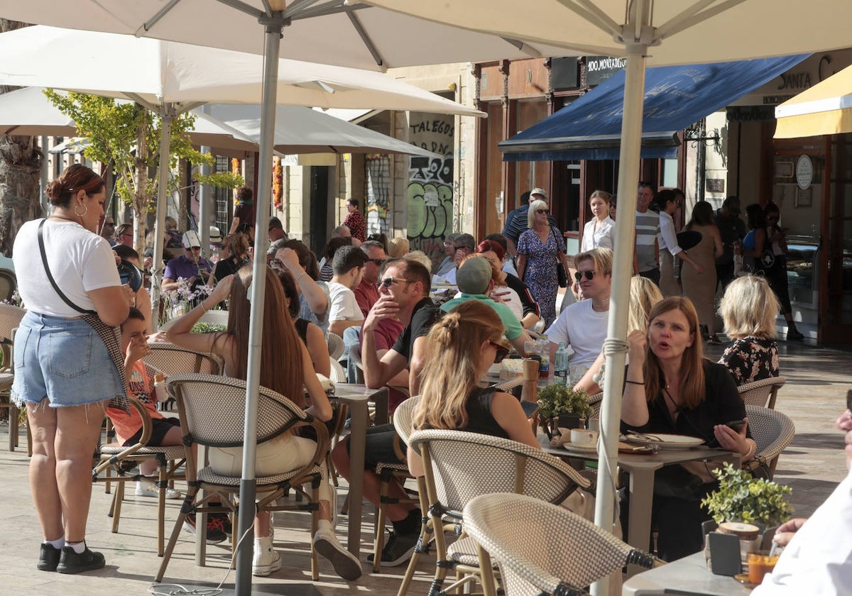 Una terraza de un restaurante repleta de clientes.