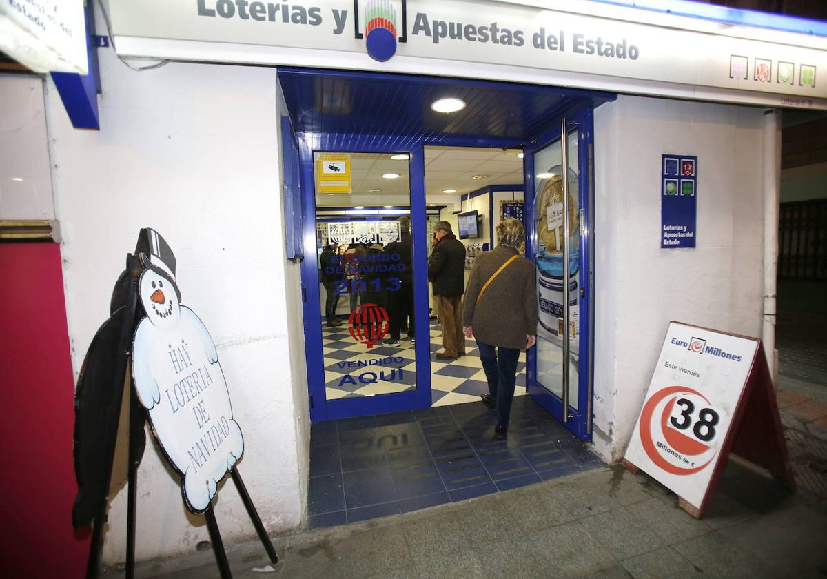 Varias personas guardan cola en la administración de lotería.